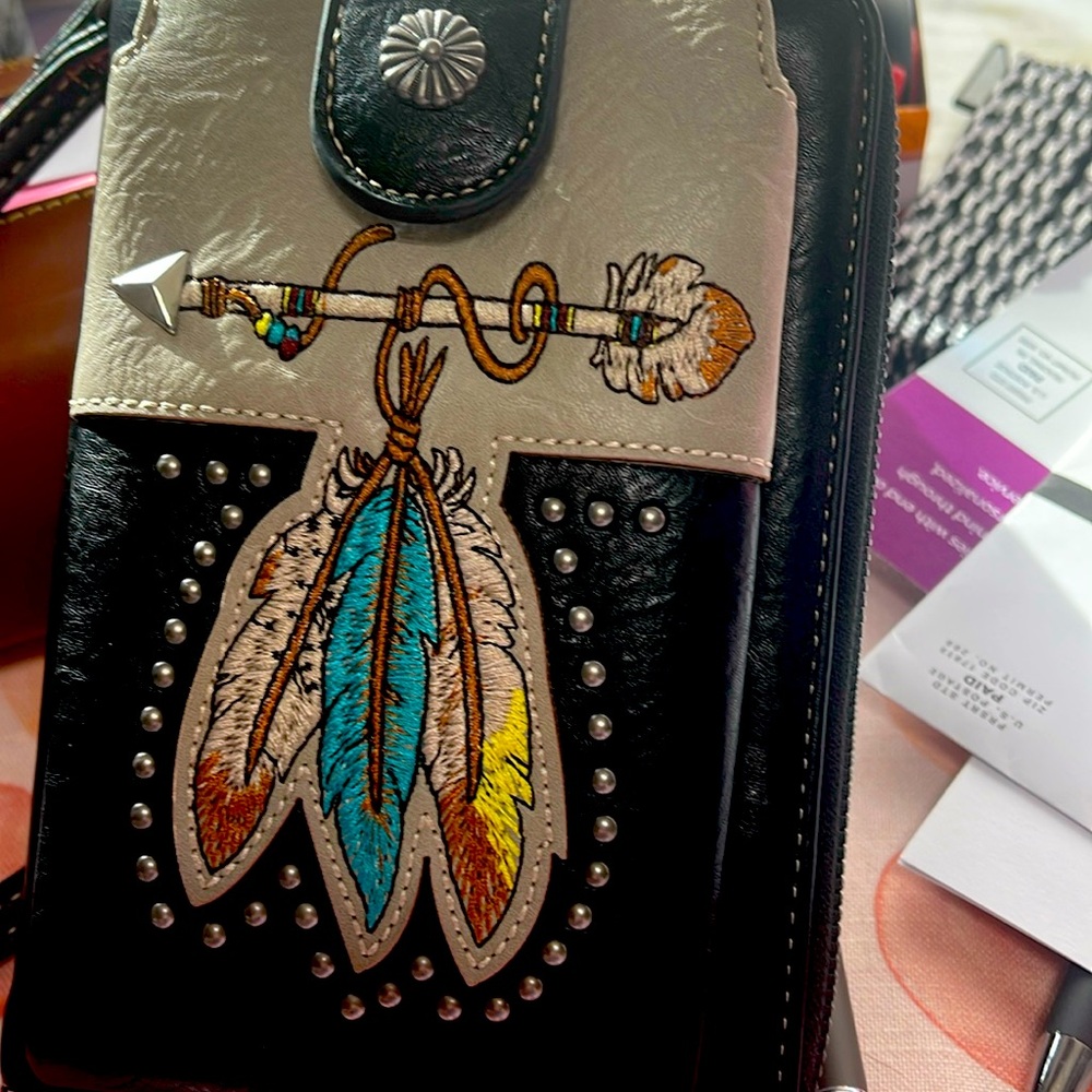 Indian feathers on front. Holds your cell phone in front and wallet inside